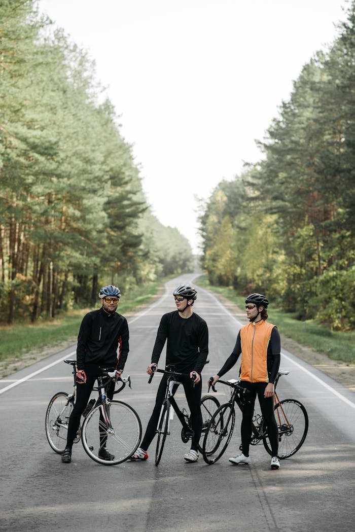 about-us-01 Three cyclists standing with bikes on a forest road, perfect image for outdoor sports and adventure.